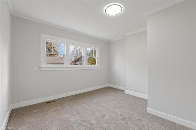 carpeted empty room featuring crown molding