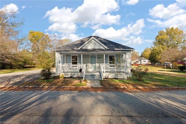 bungalow-style home with covered porch and a front yard