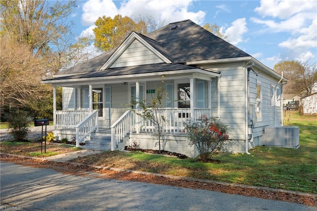 bungalow-style house with a porch, central air condition unit, and a front yard