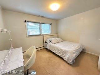 carpeted bedroom featuring baseboard heating and baseboards