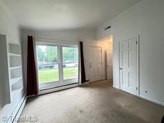 empty room with carpet flooring and baseboard heating