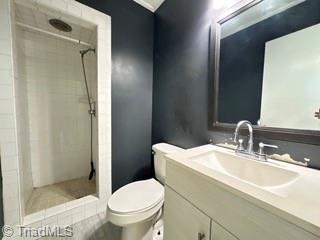 bathroom with a shower stall, toilet, and vanity