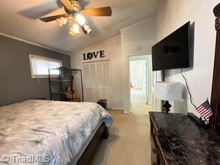bedroom with crown molding, vaulted ceiling, and a ceiling fan