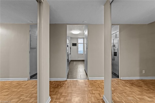 interior space featuring a textured ceiling and light parquet flooring