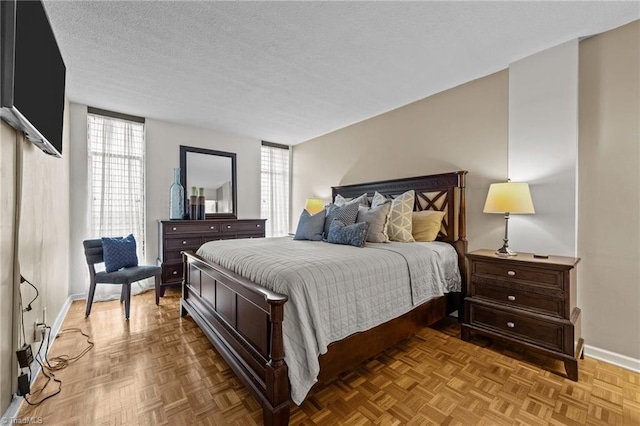 bedroom with a textured ceiling and light parquet floors