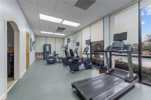 gym featuring a drop ceiling and expansive windows