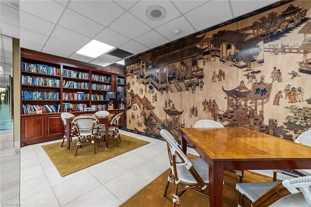 tiled dining space featuring a paneled ceiling