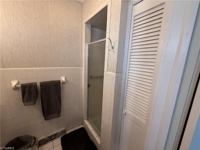 bathroom featuring an enclosed shower, tile patterned flooring, and tile walls