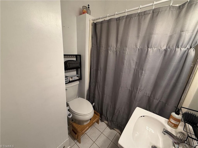 bathroom featuring toilet, sink, tile patterned flooring, and a shower with shower curtain