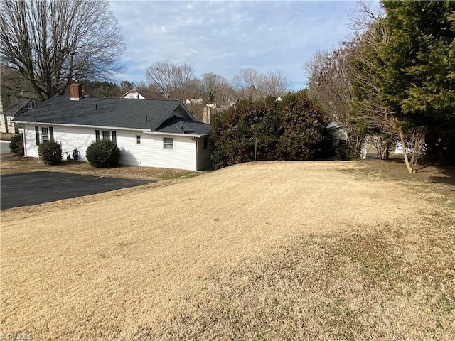 view of property exterior with a garage and a yard