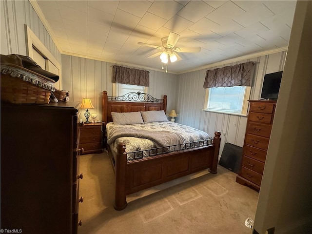 carpeted bedroom with ornamental molding and ceiling fan