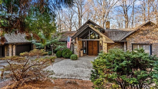 view of front of property with stone siding and a chimney