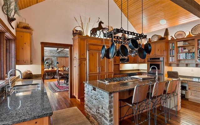 kitchen with dark wood finished floors, brown cabinets, appliances with stainless steel finishes, and a sink