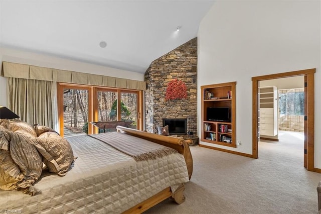 carpeted bedroom with baseboards, high vaulted ceiling, a stone fireplace, and access to exterior