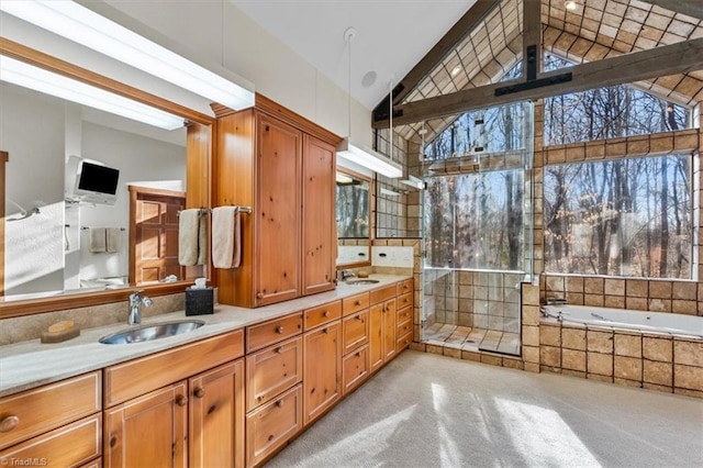 bathroom featuring double vanity, tiled shower, and a sink