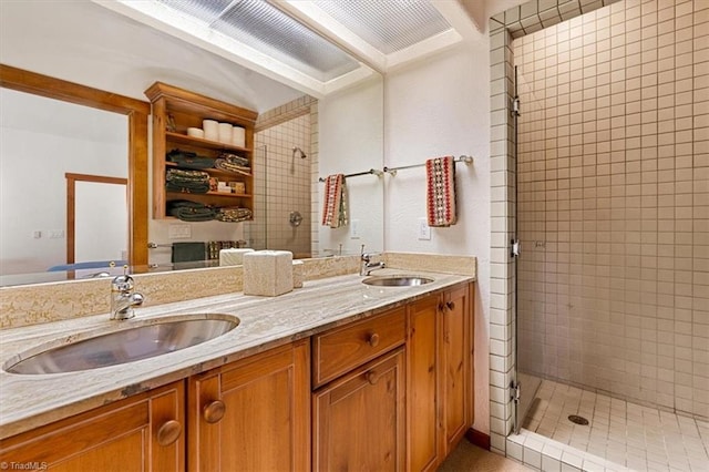 full bathroom with double vanity, a shower stall, and a sink