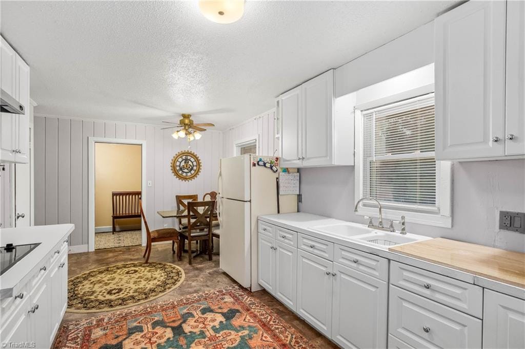 kitchen featuring ceiling fan, sink, white cabinets, and white refrigerator