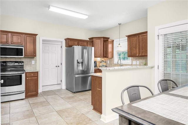 7255 Orchard Path Dr, Clemmons, NC 27012 - kitchen featuring stainless steel appliances, backsplash, hanging light fixtures, a peninsula, and light tile patterned floors