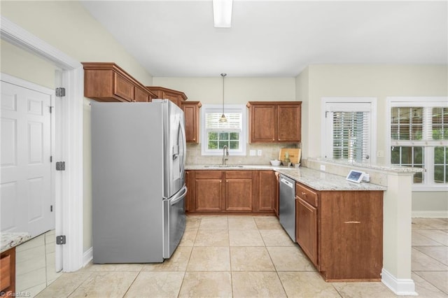 7255 Orchard Path Dr, Clemmons, NC 27012 - kitchen with appliances with stainless steel finishes, a peninsula, brown cabinetry, light stone countertops, and decorative backsplash