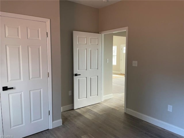 unfurnished bedroom featuring baseboards and wood finished floors