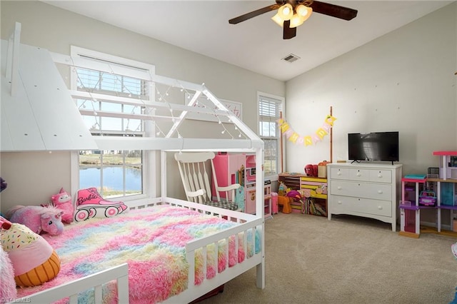 carpeted bedroom with visible vents, ceiling fan, and vaulted ceiling