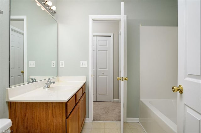 full bath with vanity, baseboards, and a bathing tub