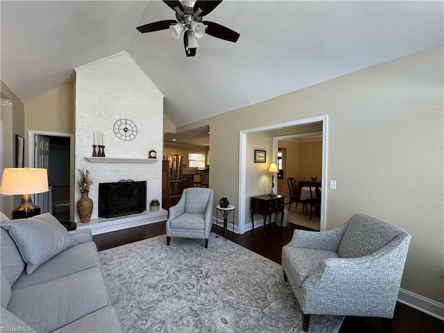 living room featuring lofted ceiling, a brick fireplace, ceiling fan, and dark hardwood / wood-style flooring