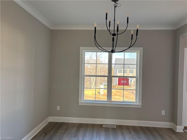 unfurnished dining area with an inviting chandelier, ornamental molding, and dark hardwood / wood-style flooring