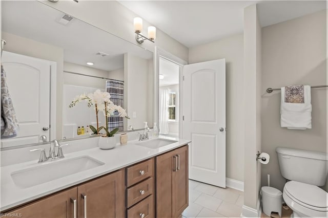 bathroom with a shower with shower curtain, tile patterned floors, vanity, and toilet