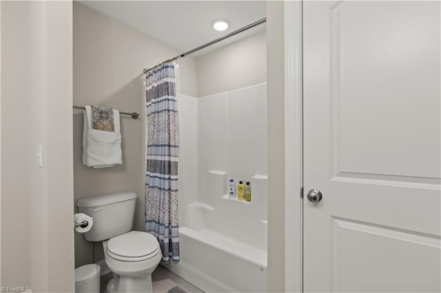 bathroom featuring shower / tub combo with curtain, tile patterned flooring, and toilet