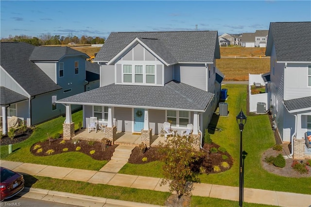 view of front of property featuring covered porch, a front lawn, and central AC unit