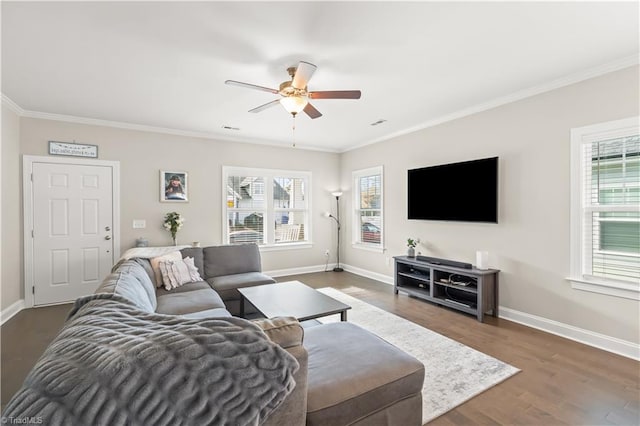 living room featuring ornamental molding, dark wood-type flooring, and a healthy amount of sunlight