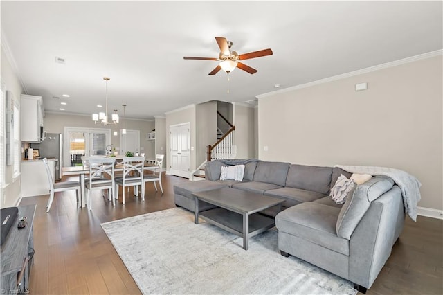 living room with ceiling fan with notable chandelier, hardwood / wood-style flooring, and crown molding