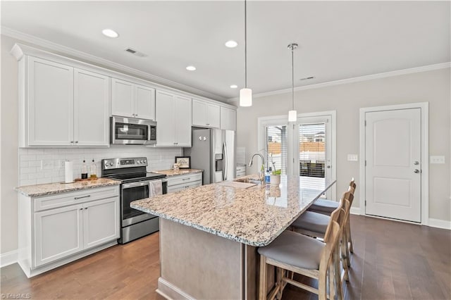 kitchen featuring a kitchen island with sink, white cabinets, sink, hardwood / wood-style flooring, and stainless steel appliances