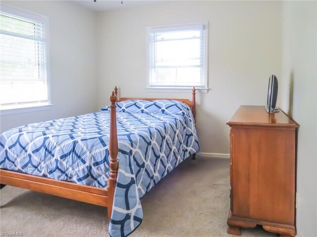 bedroom featuring carpet and baseboards