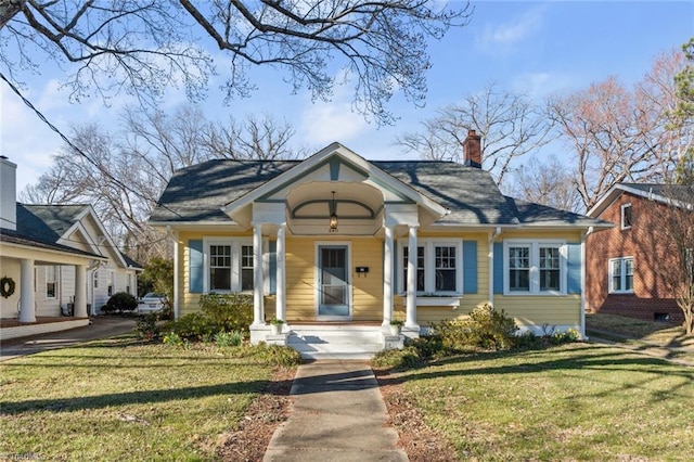 bungalow with a chimney and a front lawn