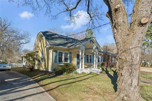 view of front of home featuring a front lawn and fence