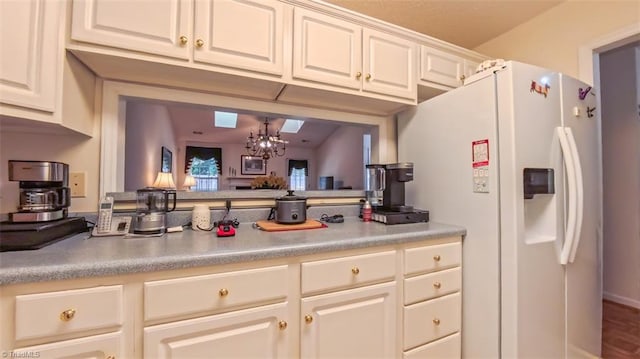 138 Wyndham Ct, High Point, NC 27265 - kitchen with white refrigerator with ice dispenser, light countertops, a chandelier, and white cabinetry