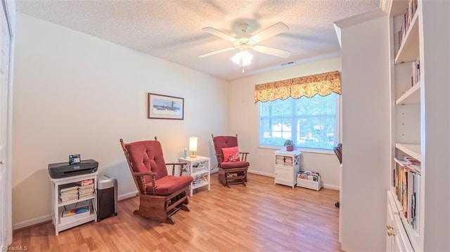 138 Wyndham Ct, High Point, NC 27265 - sitting room with light wood-type flooring, a textured ceiling, ceiling fan, and baseboards