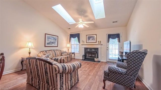 138 Wyndham Ct, High Point, NC 27265 - living room featuring lofted ceiling, a skylight, a fireplace with flush hearth, healthy amount of natural light, and baseboards