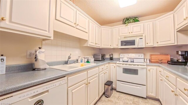 138 Wyndham Ct, High Point, NC 27265 - kitchen featuring white appliances, a sink, backsplash, white cabinetry, and light countertops
