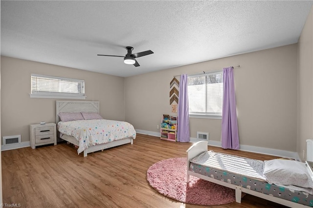 bedroom featuring ceiling fan, a textured ceiling, and hardwood / wood-style flooring