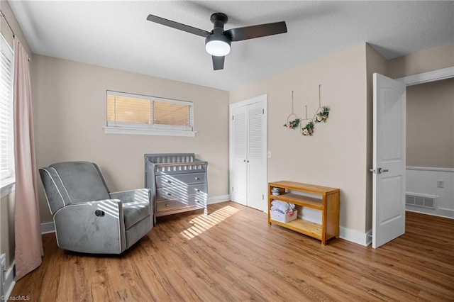 sitting room with light wood-type flooring and ceiling fan