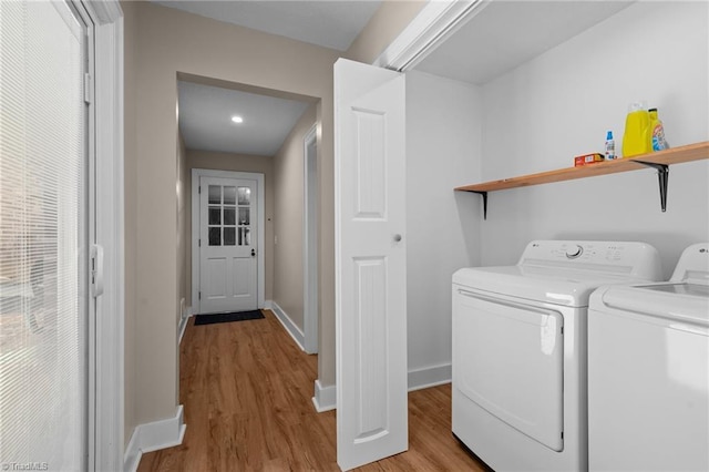 laundry room featuring light hardwood / wood-style flooring and washing machine and clothes dryer