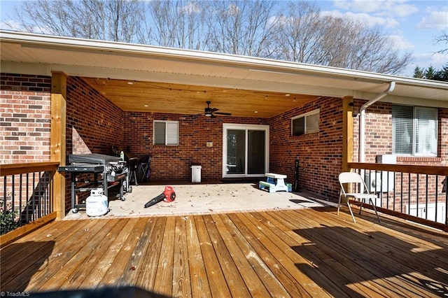 wooden terrace featuring ceiling fan and a grill