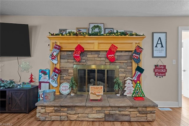 living room featuring a fireplace, hardwood / wood-style floors, and a textured ceiling