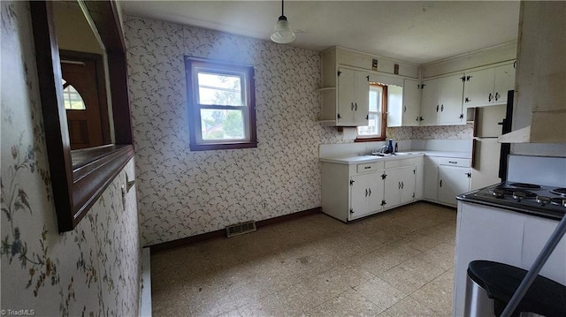 2308 Sprague St, Winston-Salem, NC 27107 - kitchen with light countertops, light floors, baseboards, a sink, and stovetop