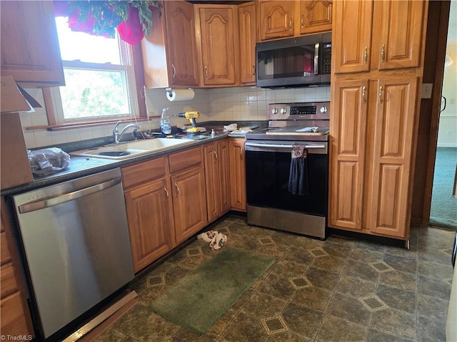 210 Grinton Ave, Wilkesboro, NC 28697 - kitchen featuring stainless steel appliances, a sink, decorative backsplash, and brown cabinetry