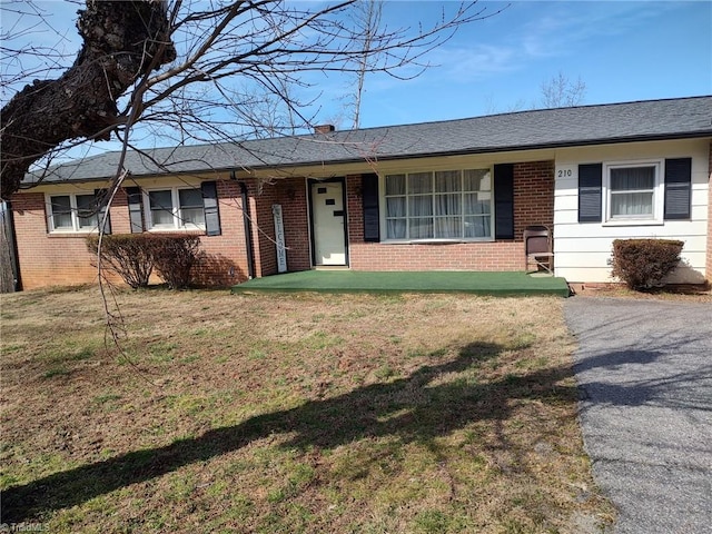 210 Grinton Ave, Wilkesboro, NC 28697 - ranch-style home featuring brick siding, a front lawn, covered porch, and a shingled roof