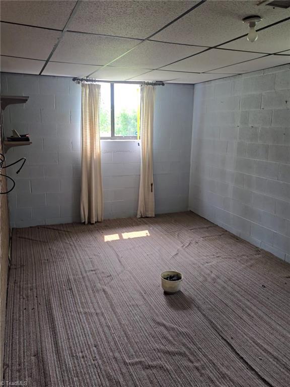 210 Grinton Ave, Wilkesboro, NC 28697 - basement with carpet, concrete block wall, and a drop ceiling